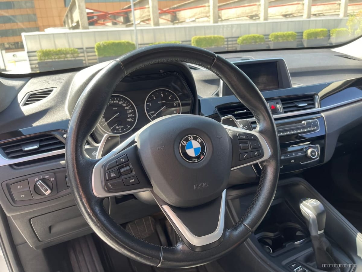BMW X1 Diesel 2018 Automático, 65.000 km - Vista interior del volante y tablero de SUV color claro en exterior