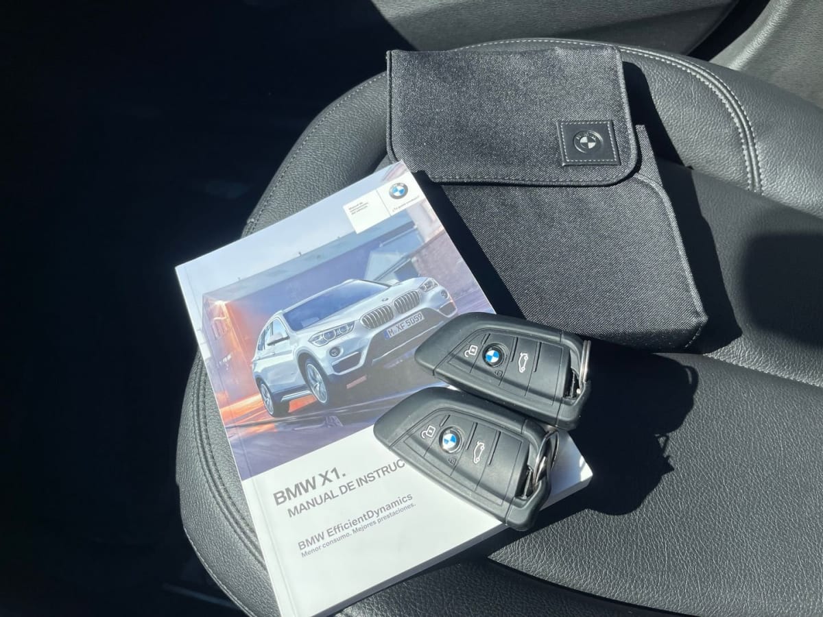 BMW X1 Diesel 2018 Automático, 65.000 km - Detalle de llaves, manual y estuche en asiento interior de vehículo