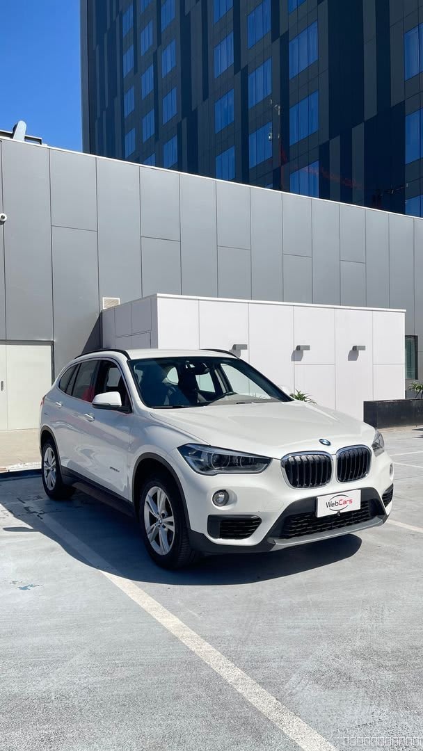 BMW X1 Diesel 2018 Automático, 65.000 km - Vista 3/4 frontal de SUV color blanco en estacionamiento exterior