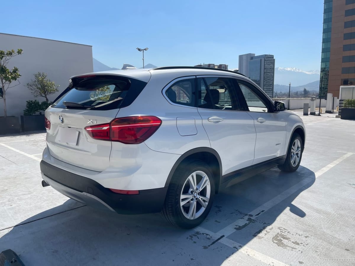 BMW X1 Diesel 2018 Automático, 65.000 km - Vista trasera 3/4 de SUV color blanco en estacionamiento exterior