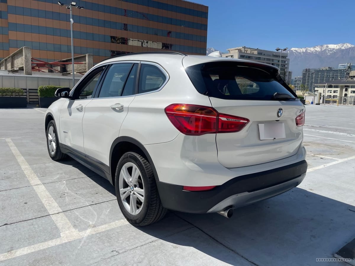 BMW X1 Diesel 2018 Automático, 65.000 km - Vista trasera 3/4 de SUV color blanco en estacionamiento exterior