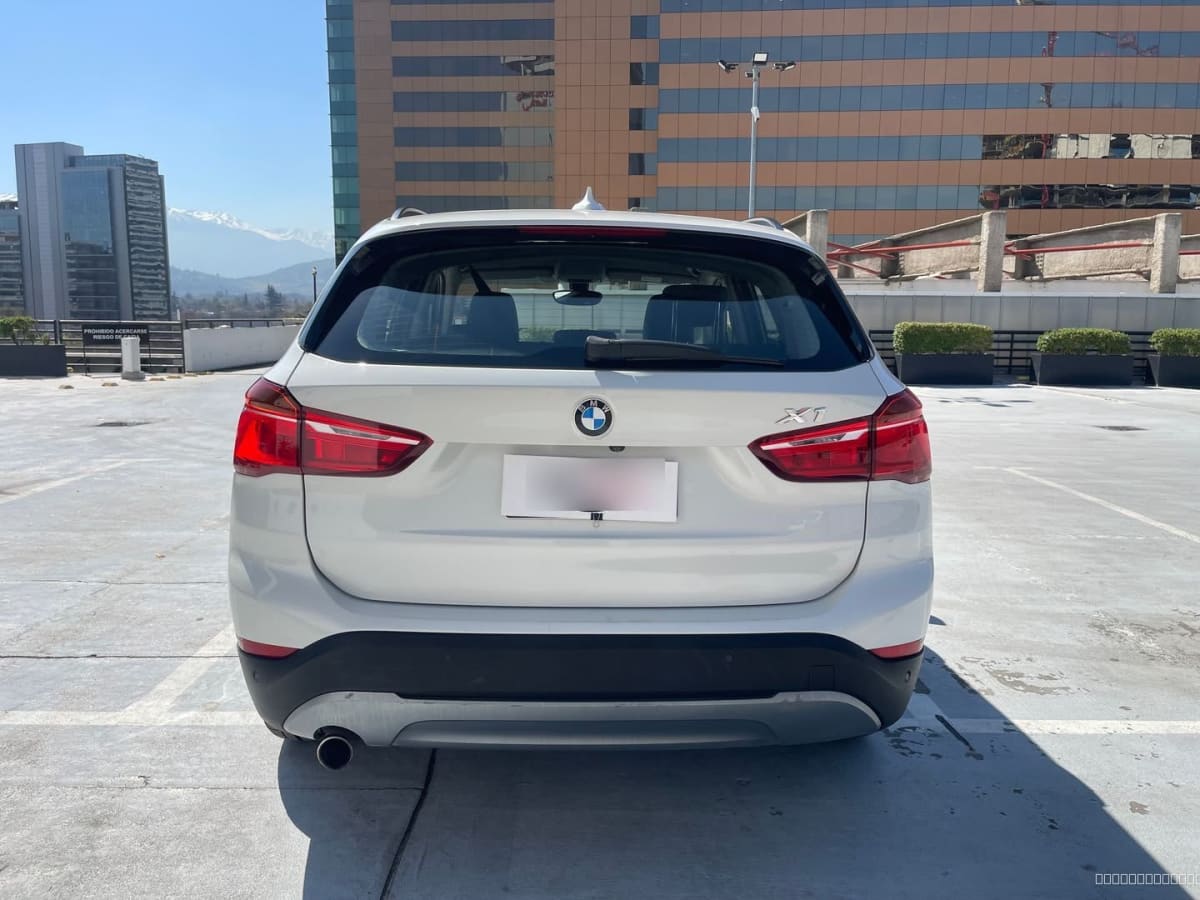 BMW X1 Diesel 2018 Automático, 65.000 km - Vista trasera de SUV color blanco en estacionamiento exterior