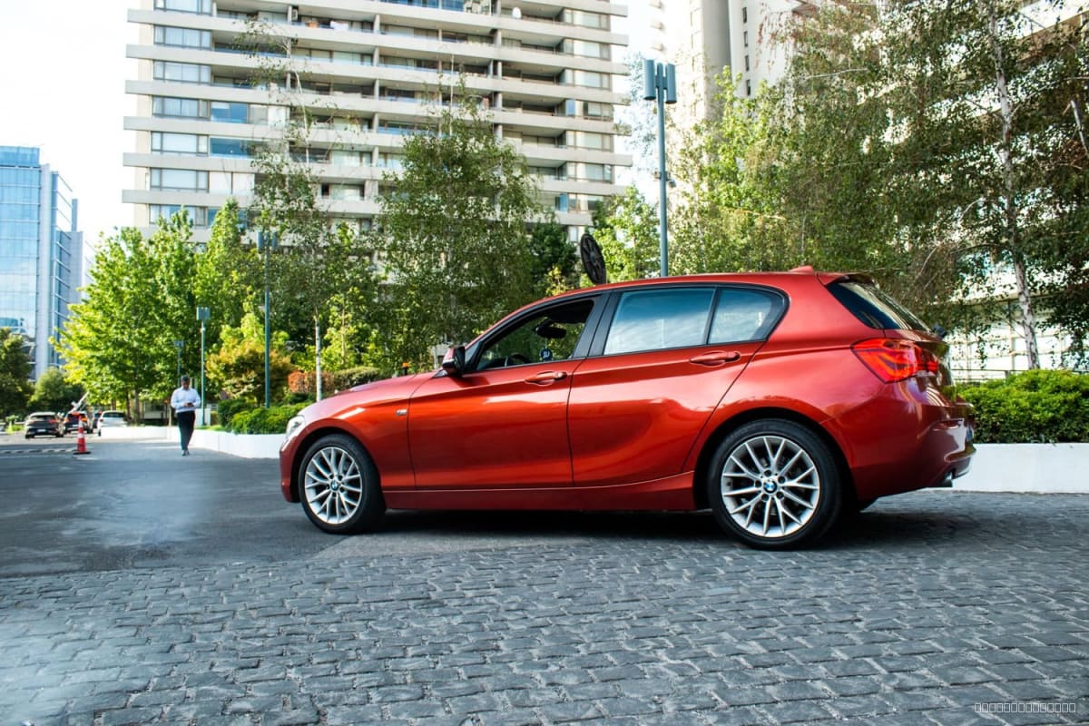 2018 BMW 118I 1.5 AUT 1.5 MILLENNIAL AT Otro - Vista lateral de hatchback color rojo anaranjado en exterior urbano