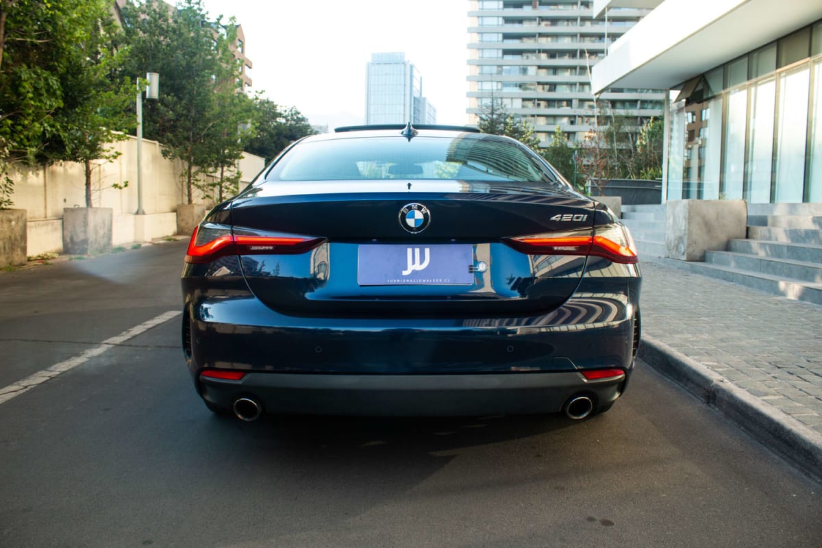 BMW 420i Coupe 2022 - Vista trasera de sedán color azul oscuro en exterior urbano