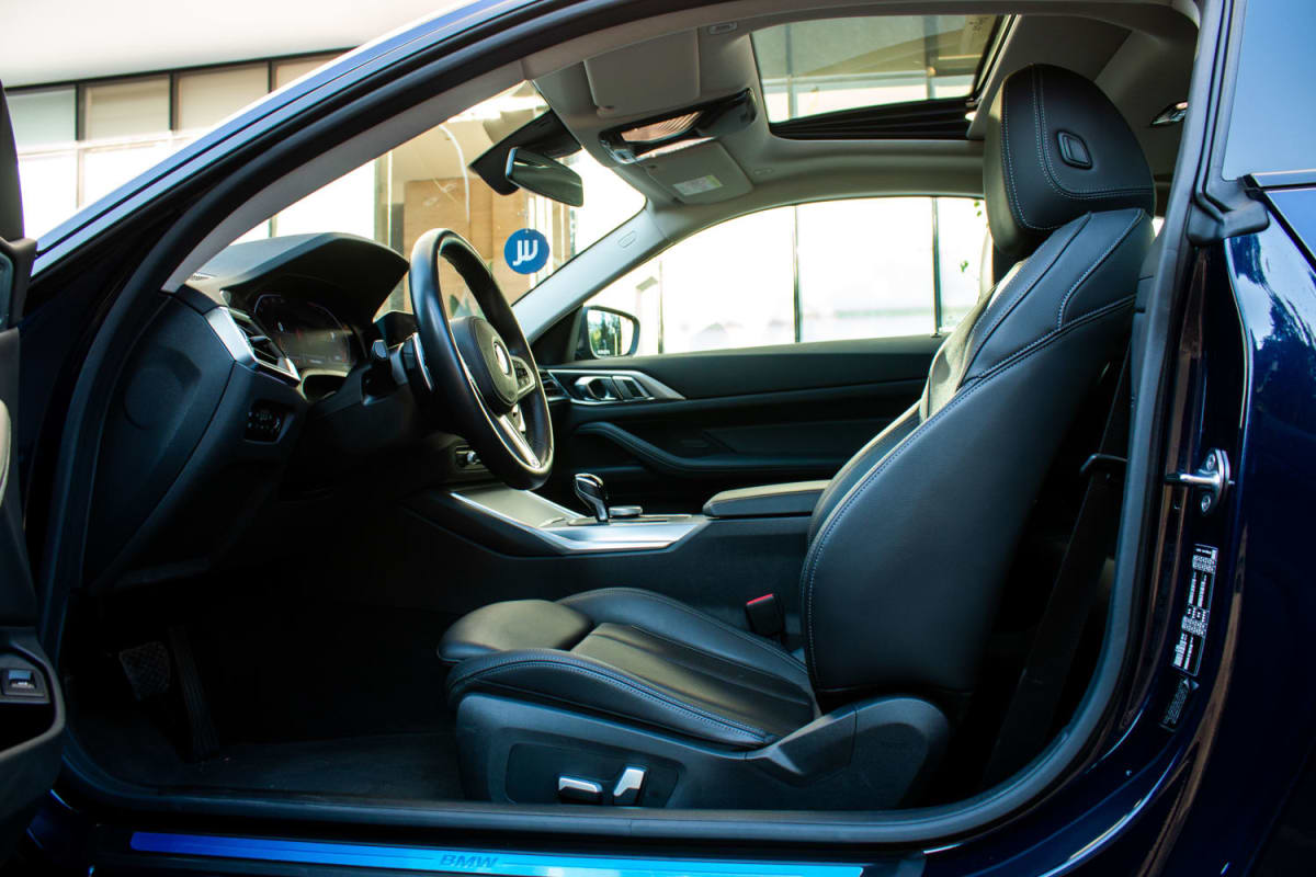 BMW 420i Coupe 2022 - Vista interior de coupé color azul con asientos de cuero negro en estudio
