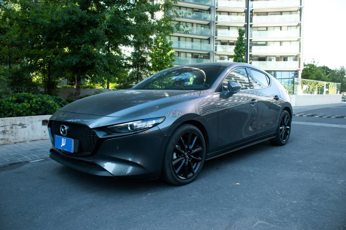 Mazda 3 2.5 2024 - Vista 3/4 de hatchback color gris oscuro en exterior