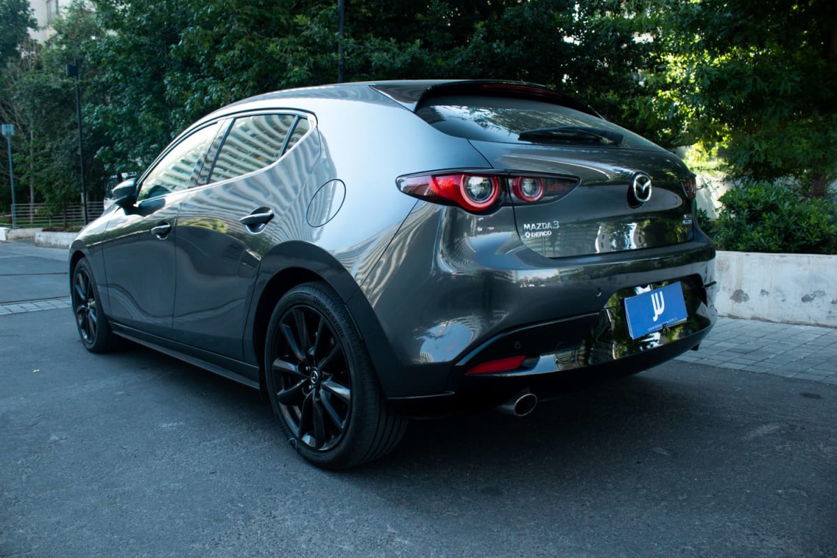 Mazda 3 2.5 2024 - Vista trasera 3/4 de hatchback color gris oscuro en exterior