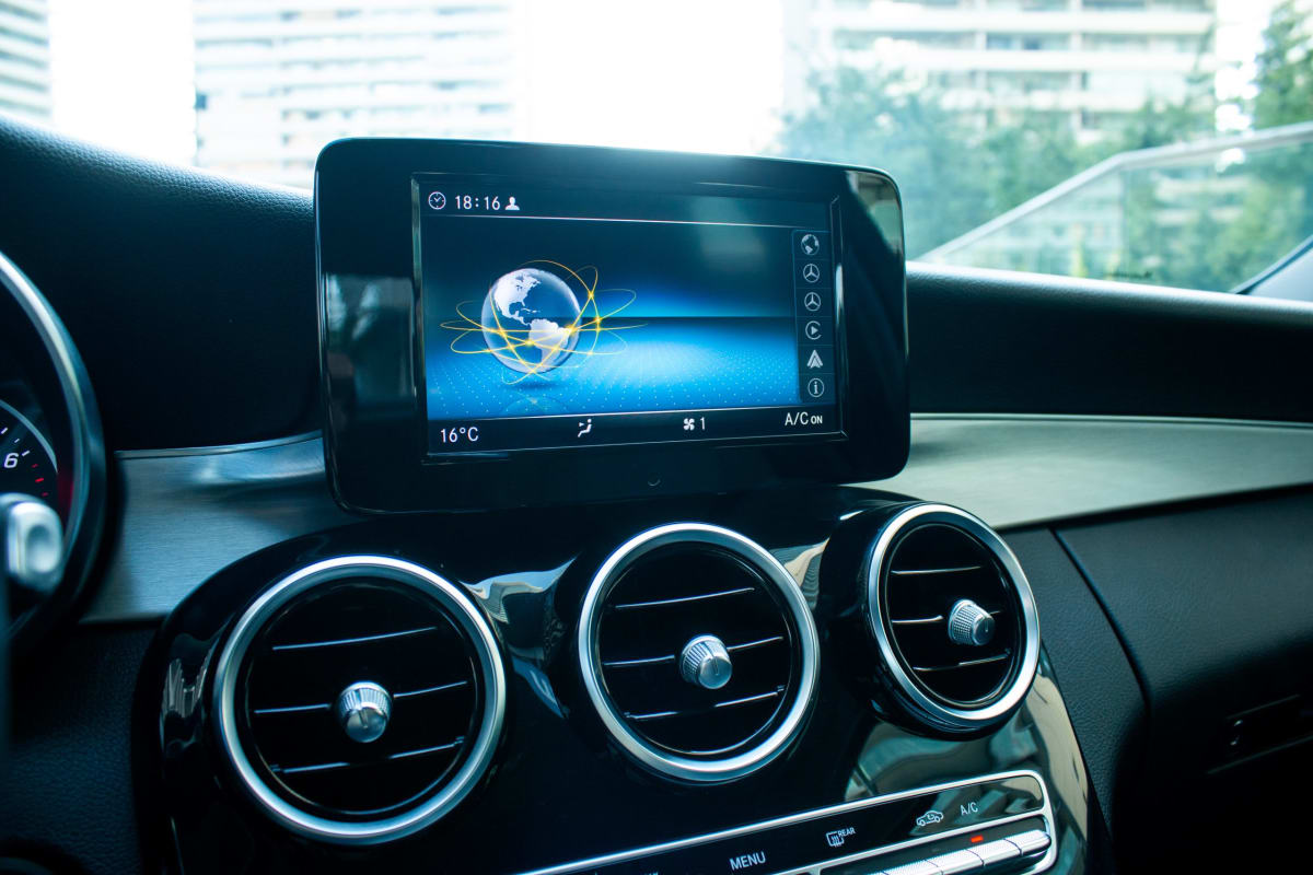 Mercedes-Benz C180 1.6 2020 - Detalle interior de consola central negra con pantalla y salidas de aire circulares.