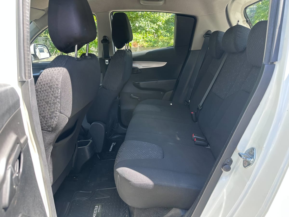 Mahindra XUV100 2021 - Vista interior de pickup color blanco, asientos traseros de tela negra en exterior
