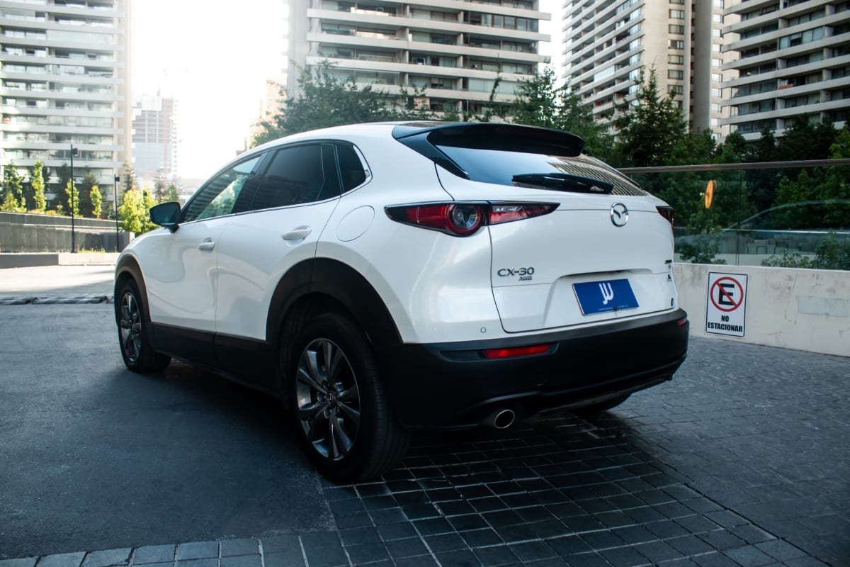 Mazda CX-30 High 2024 - Vista trasera 3/4 de SUV color blanco en exterior urbano