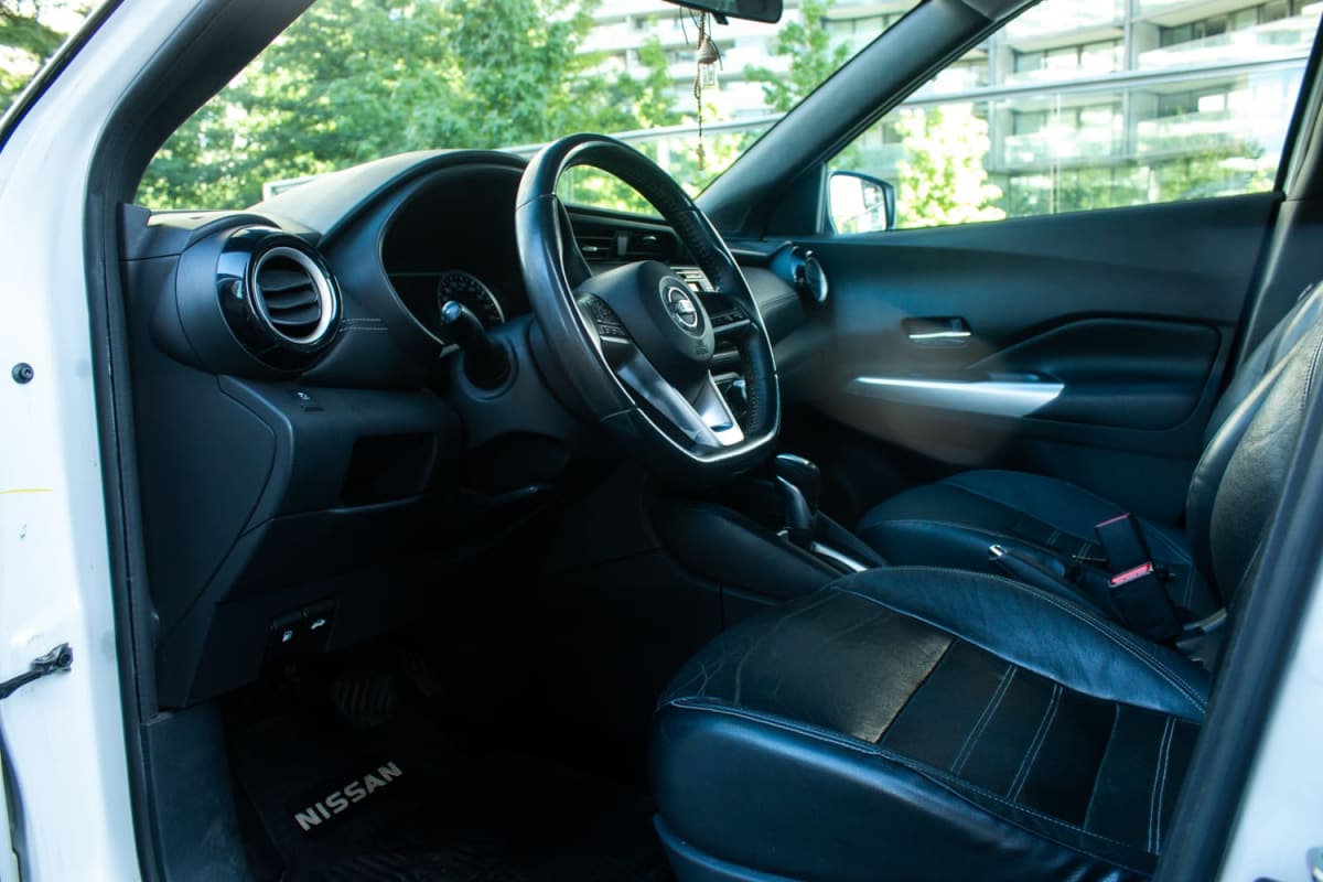Nissan Kicks 1.6 2017 - Vista interior de SUV blanco, detalle de asientos y panel frontal en exterior.