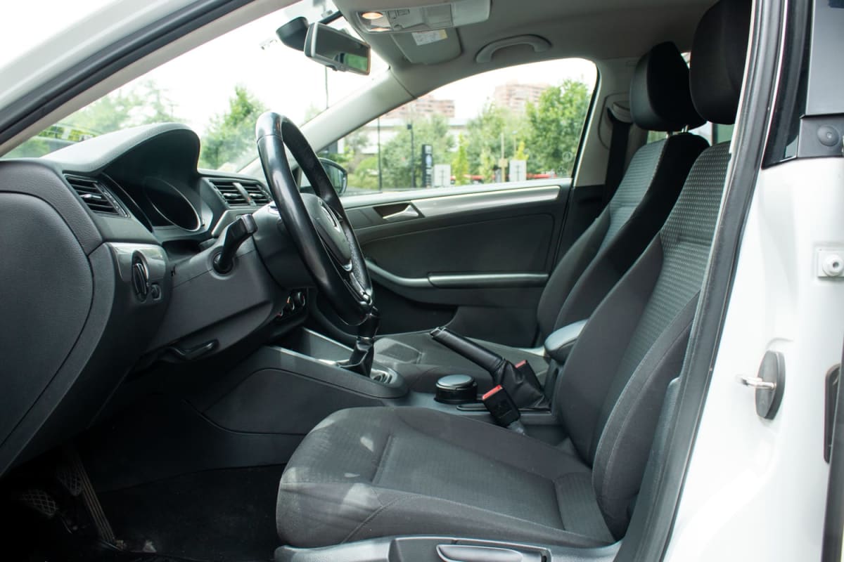 Volkswagen Bora 1.4 2015 - Vista interior de sedán color blanco. Detalle de asientos delanteros y panel de control. Exterior.