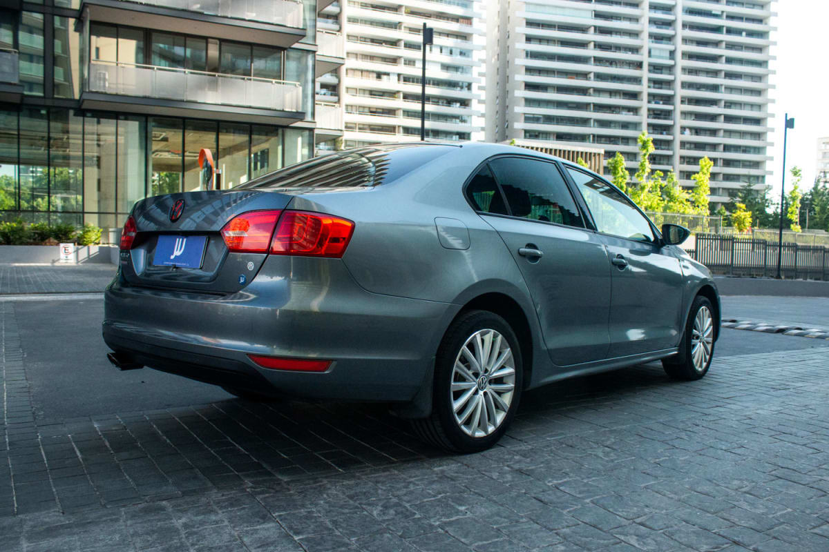 Volkswagen Vento 2.0 2013 - Vista trasera 3/4 de sedán color gris en exterior urbano