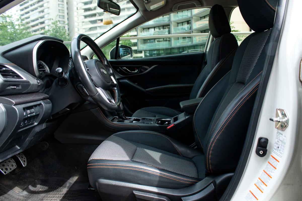 Subaru XV Dynamic 2020 - Vista interior de SUV color blanco, asientos de tela negros con costuras naranjas. Exterior.