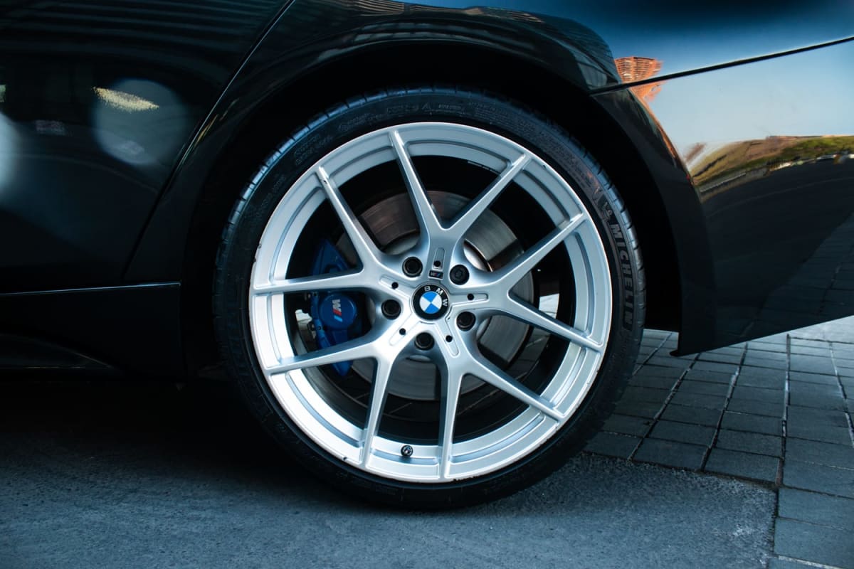 BMW 340i 40 2017 - Detalle de rueda plateada y freno azul en sedán negro. Exterior.