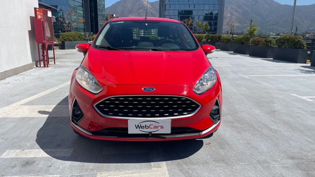 Ford Fiesta SE 2019 rojo manual - Vista frontal de hatchback color rojo en estacionamiento exterior