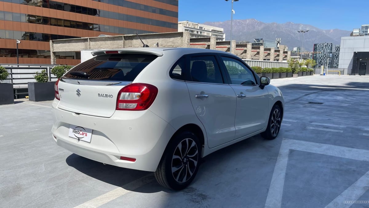 2022 Suzuki Baleno GLX AUTO Blanco - Vista trasera 3/4 de hatchback color blanco en estacionamiento exterior