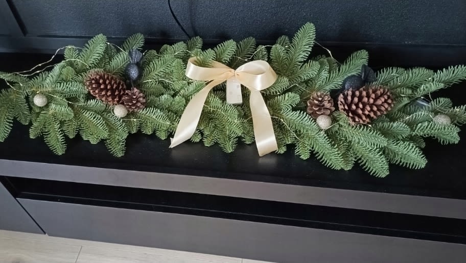 girlanda przystrojona biala kokarda i szyszkami
