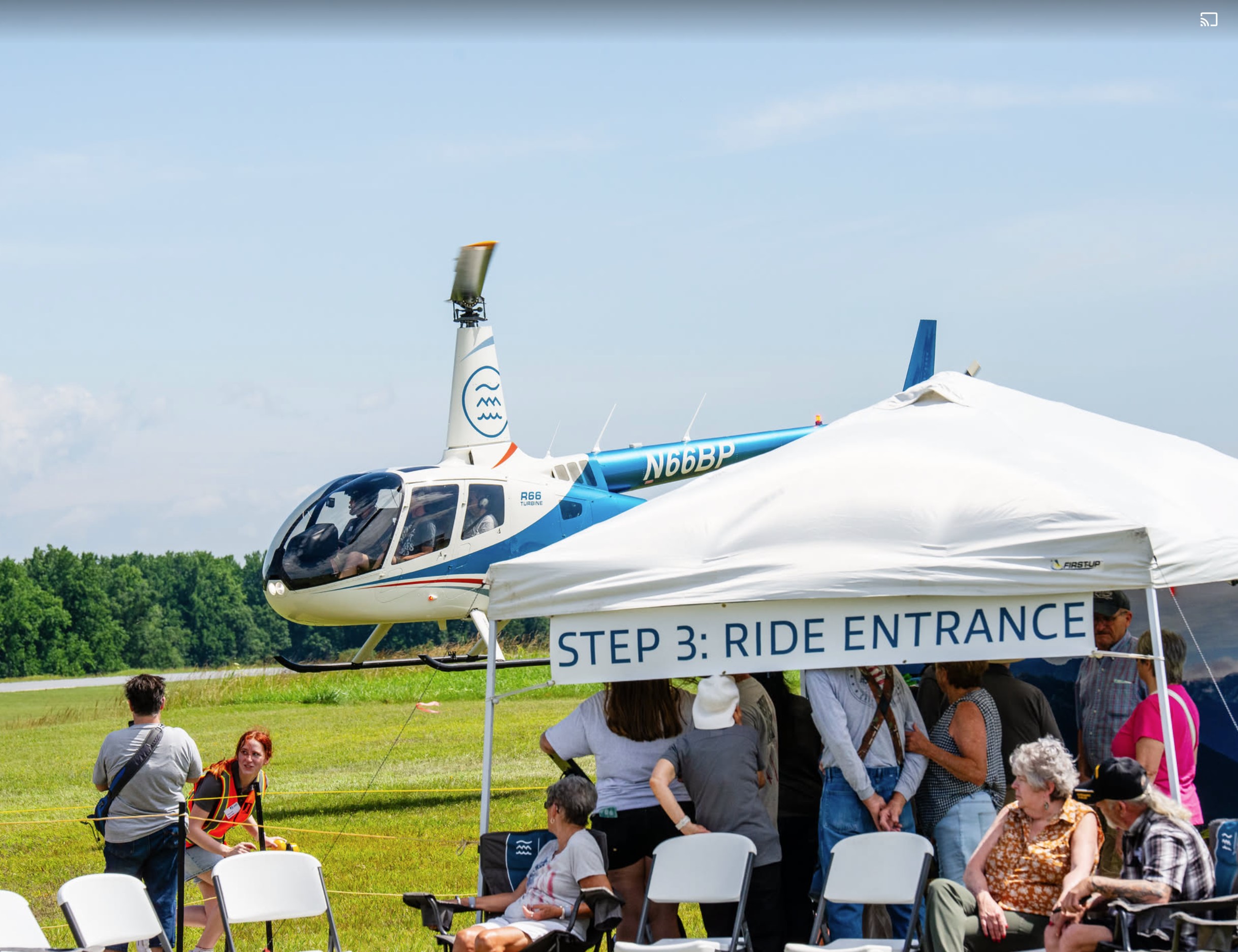 Robinson R66 flying with tent in foreground