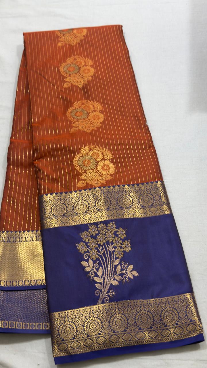 A delicate soft-pink Kanjivaram Silk Saree with fine vertical gold zari stripes and elegant floral motifs. The plum contrast pallu creates a rich visual balance, while the ornate gold zari borders add view 1 - Rangam Saradha Silks