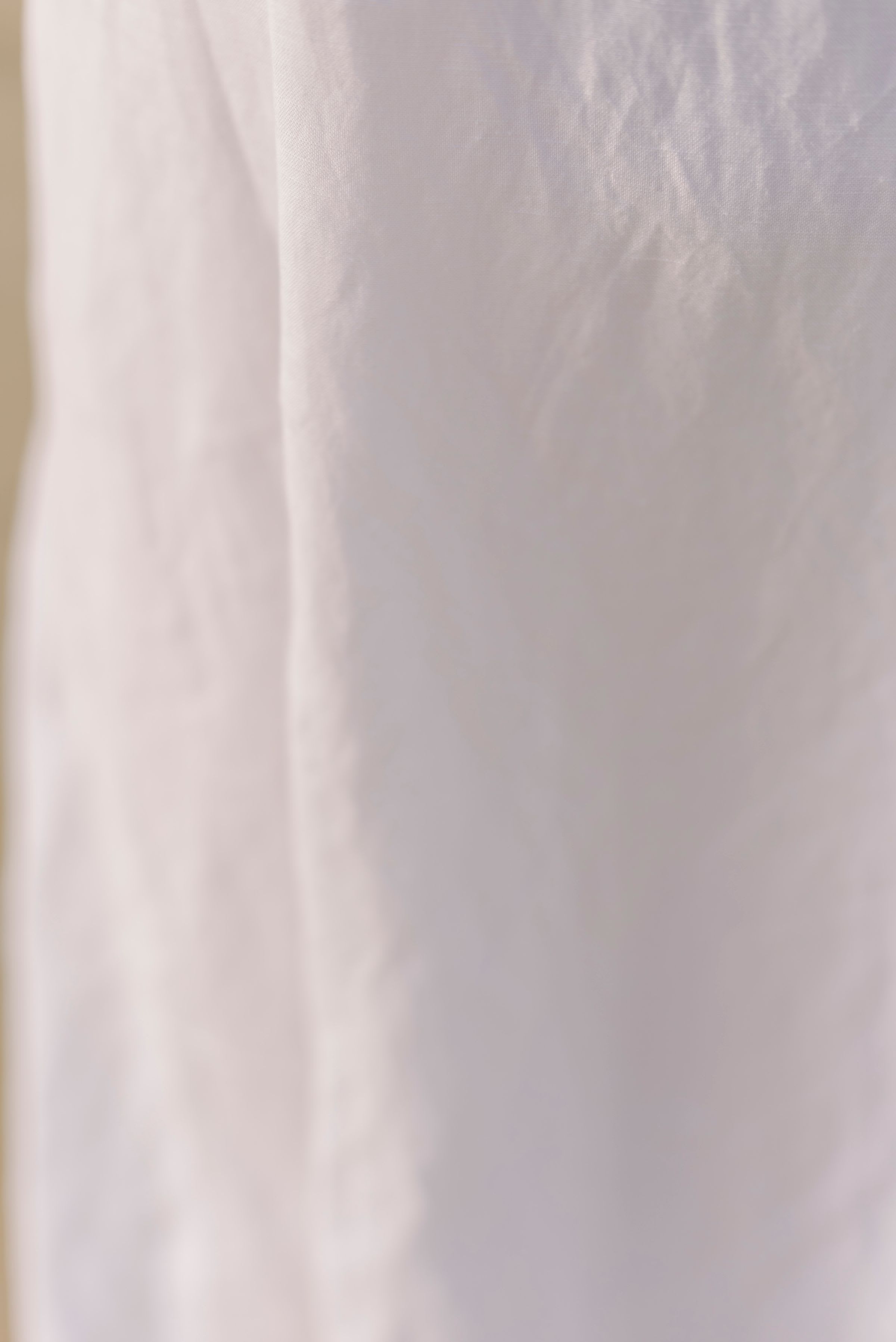 Soft white linen fabric falling in loose folds