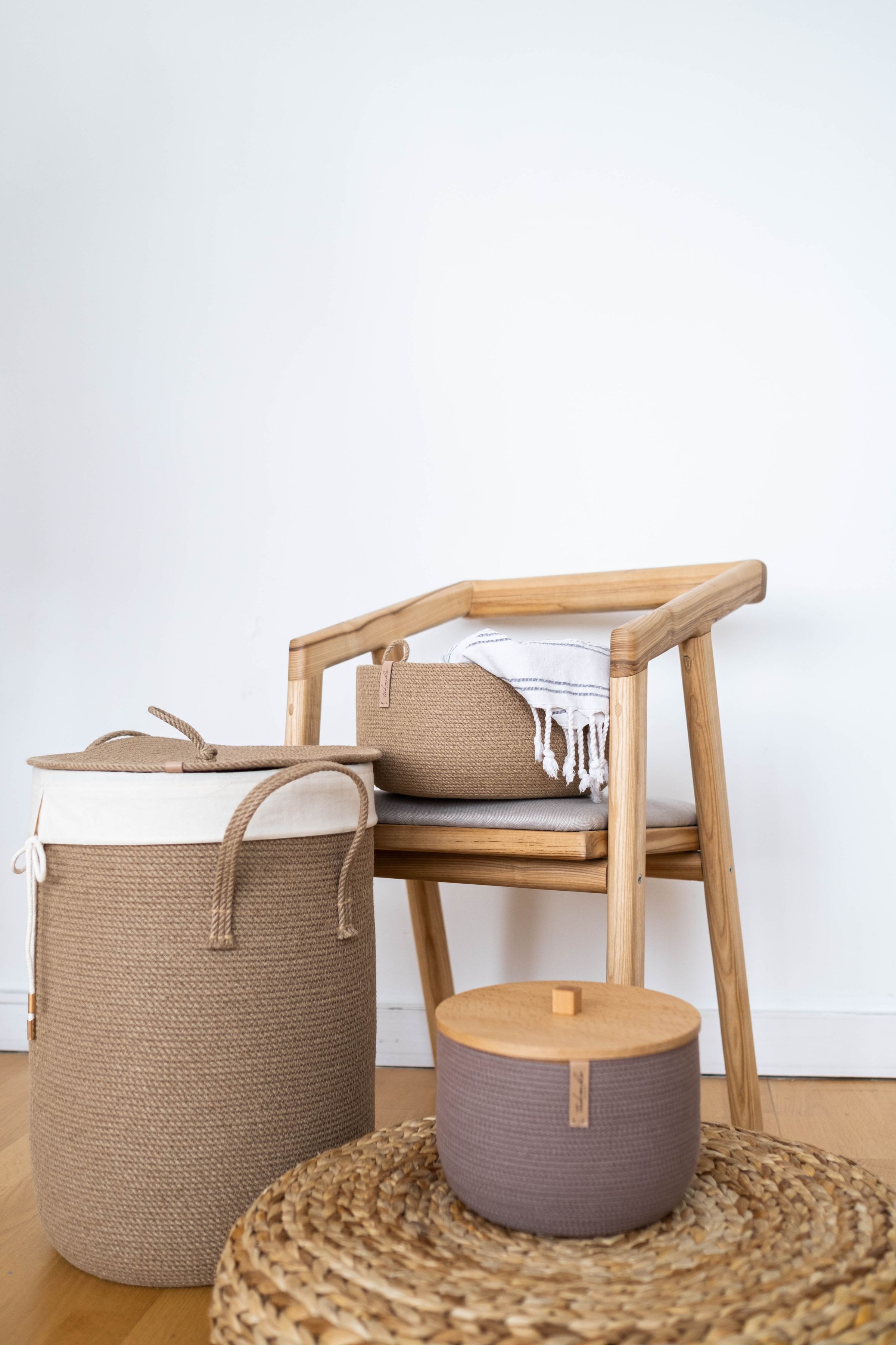 Woven storage baskets beside a wooden chair in a white room