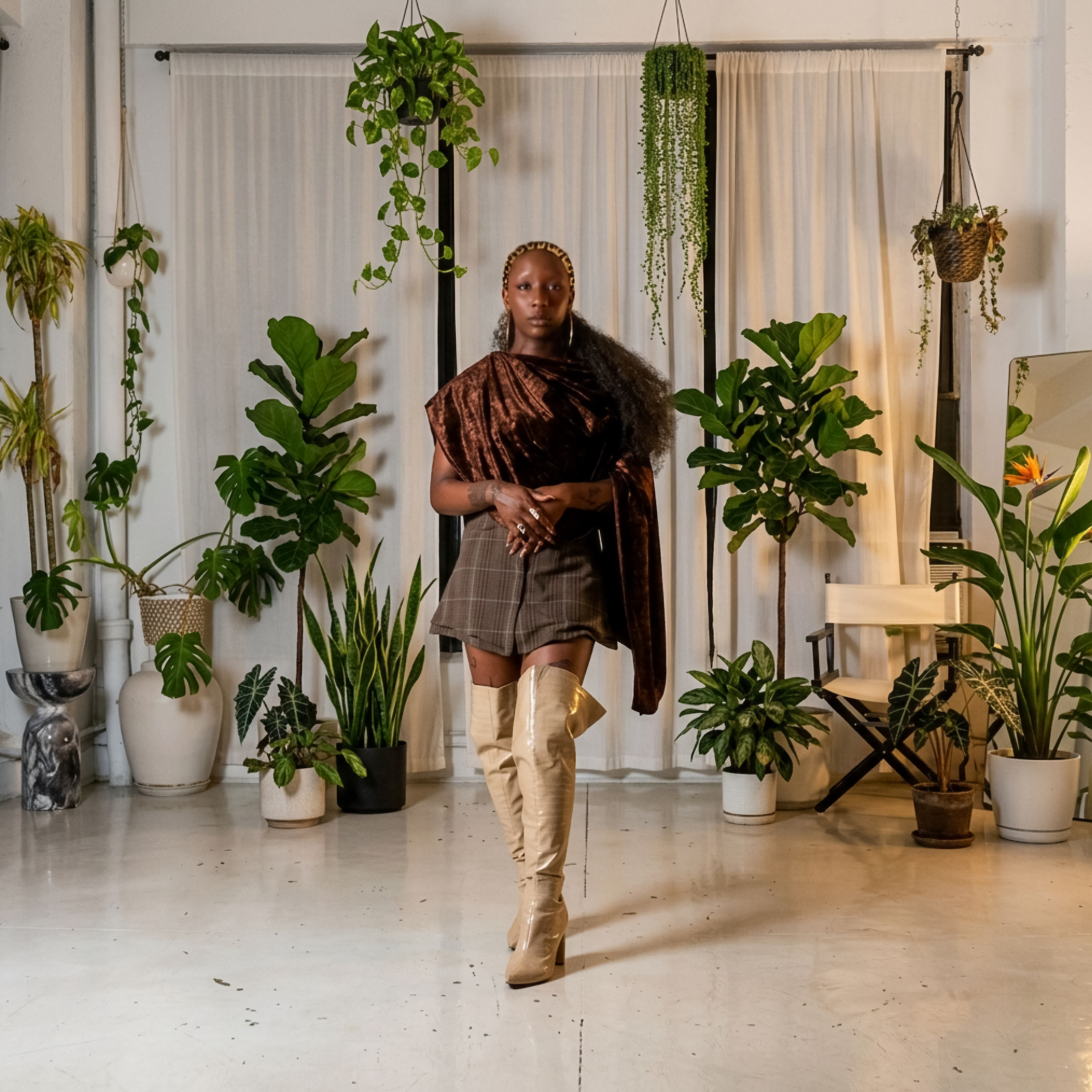 Aziza Love surrounded by plants in the studio
