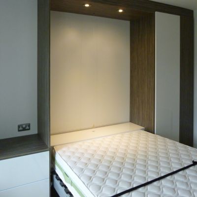 foldaway bed in wardrobe with bedside table