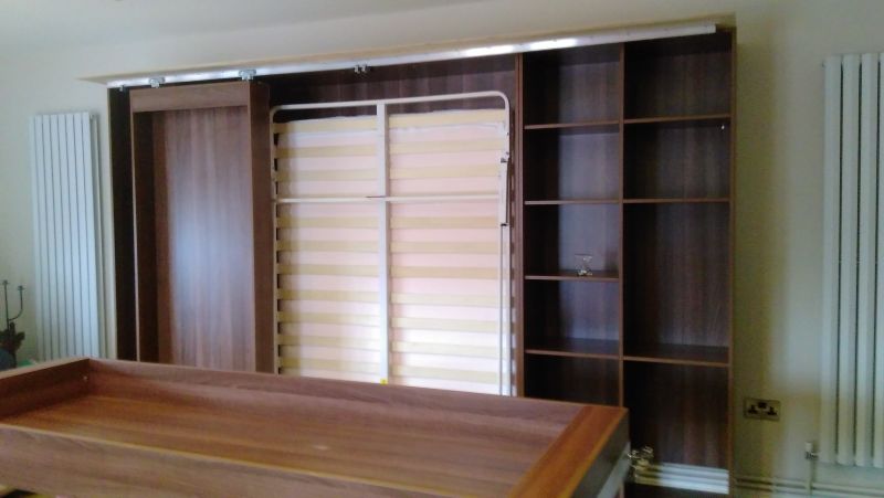 Bookcases removed to show wallbed mechanism behind