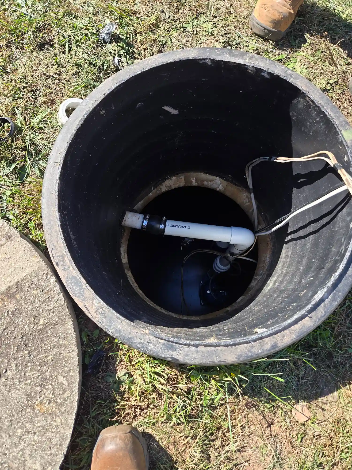 Top-down view of a Mechanicsburg sewage ejector basin with pump, discharge, and floats neatly secured