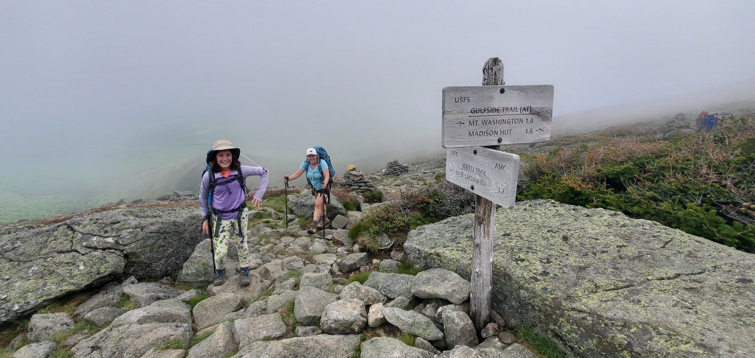 Smiling at the trail junction as the clouds close in