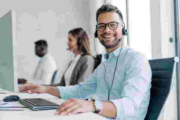 Smiling, confident, handsome contact center agent looking at the camera
