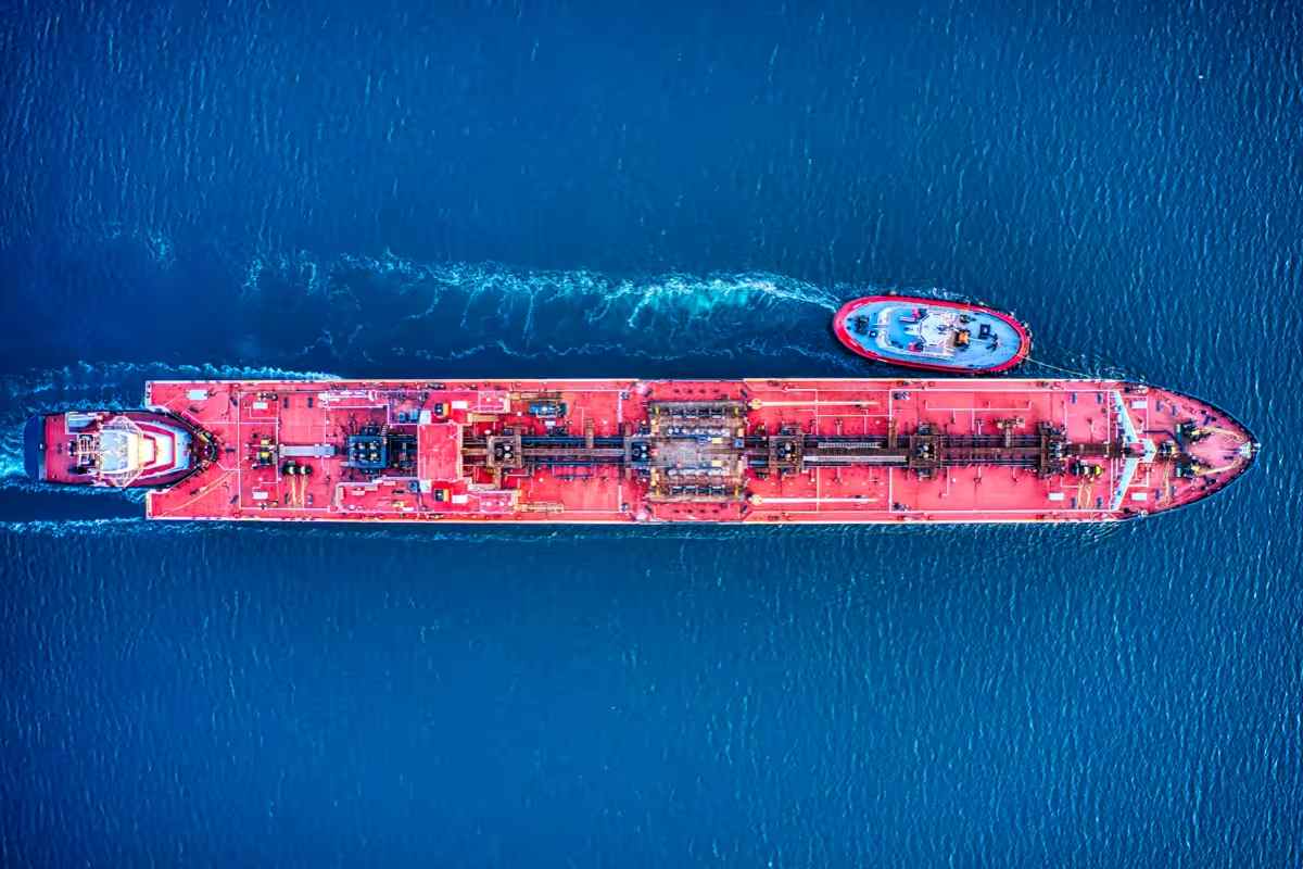 aerial view from drone of red oil tanker and red tug at sea