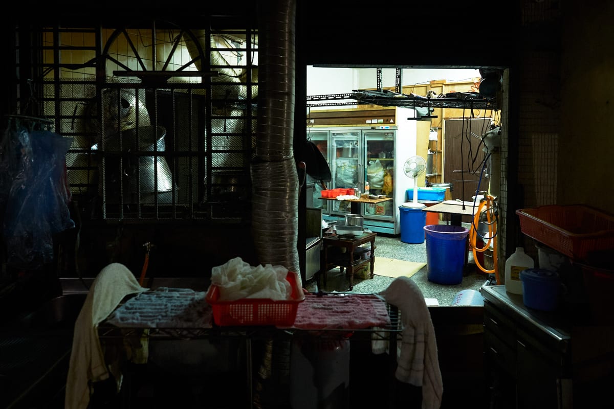 A food store has things put away for the night, but the doors open to air out the place.