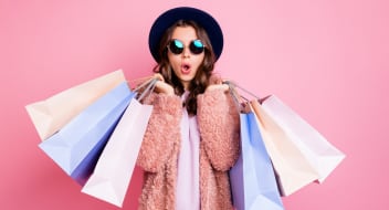 woman with shopping bags on a pink background