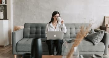 a woman sitting on a couch with a laptop