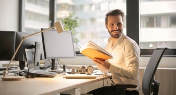 a man sitting by a computer looking to his left