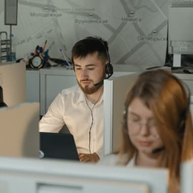 a man sitting in front of a computer in an open space