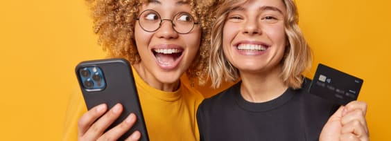 two young girls holding a telephone and a credit card