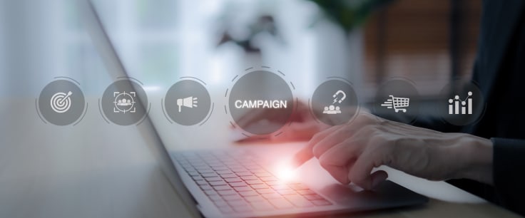 Marketing campaign concept. Businessman using a laptop with icons representing various aspects of a digital marketing campaign, including targeting, customer engagement and data analytics.