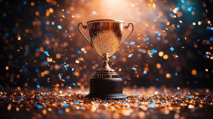 The image showcases an illuminated trophy in the center, surrounded by swirling colorful confetti, creating an atmosphere of joy and achievement with vibrant energy.