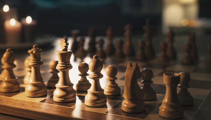 Chess pieces arranged on the chessboard in the living room, board games and hobbies concept