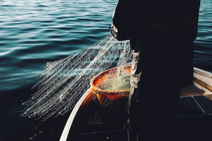 A man casting a net into the sea, an analogy to attracting prospective customers. 