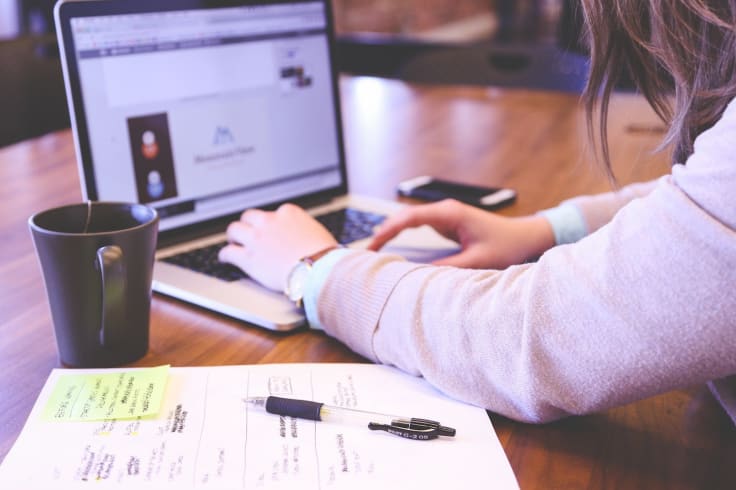 Laptop writing notes how to do market research