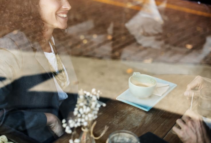 Woman coffee shop behind window smiling