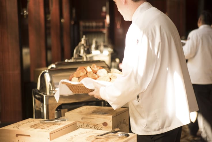 Elegant waiter holds bake goods breakfast