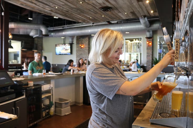 Waitress filling a glass up with beer