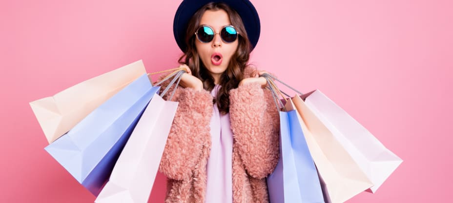 woman with shopping bags on a pink background