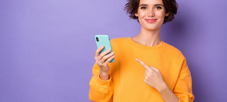 a young woman in a yellow jumper pointing at the telephone