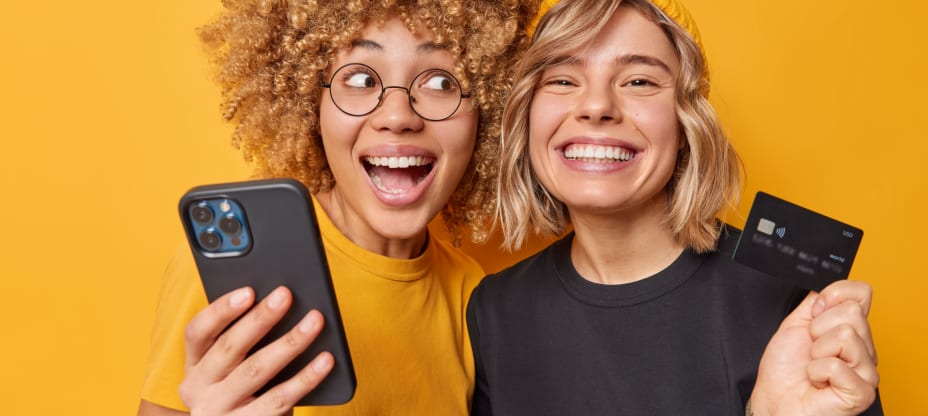 two young girls holding a telephone and a credit card